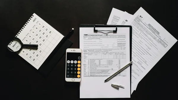 Tax forms and a calculator on a desk, the tax code and VAT number that follow registration