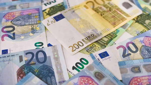 Euro banknotes and coins on a table, the share capital of an S.r.l.