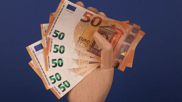 Euro banknotes being handed over, the cash contribution paid to the management body