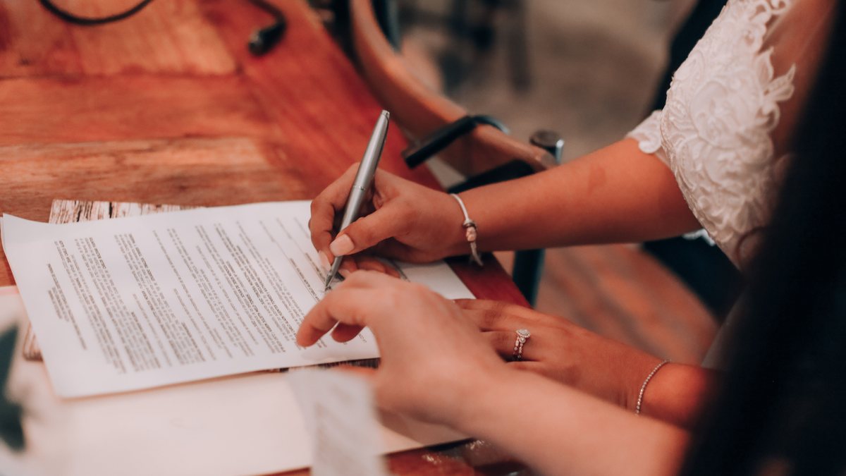 Signing a document across a meeting table