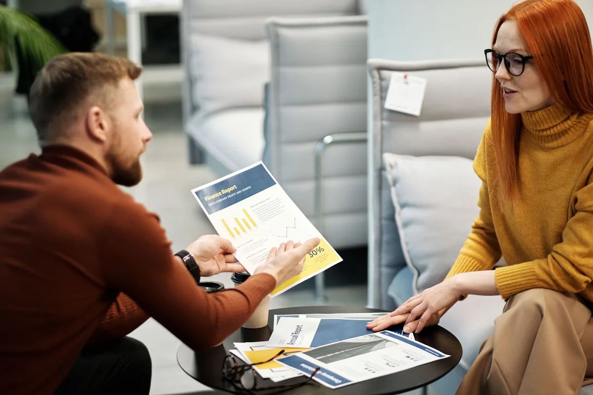 Two people going through filing deadlines at a meeting room table