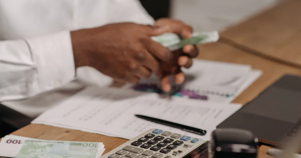 A payslip and a calculator on an office desk
