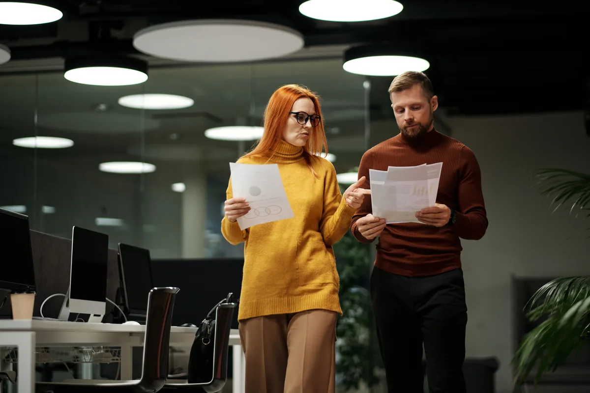 Two colleagues reviewing paperwork in a small office